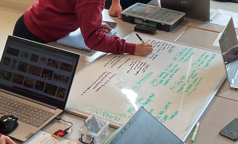 Students using a white board to brainstorm